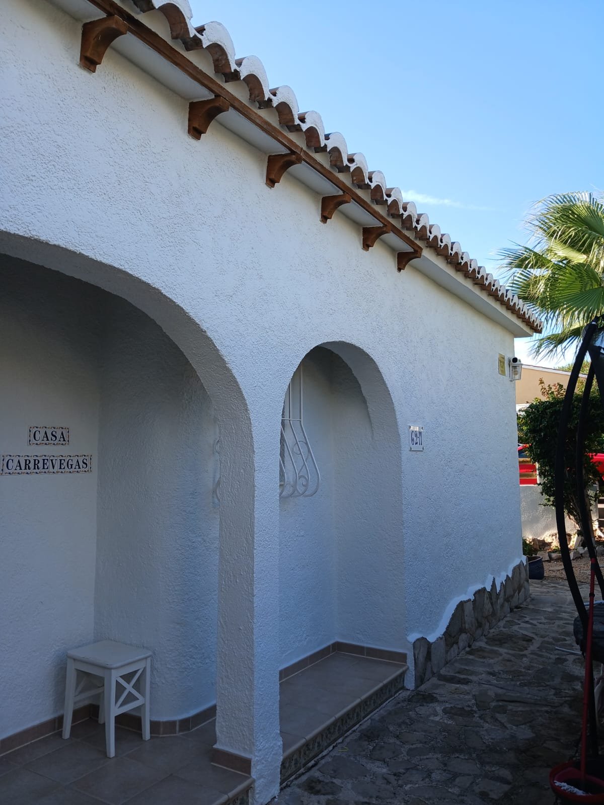 A whitewashed villa entrance with archways, named 'Casa Carrevegas'